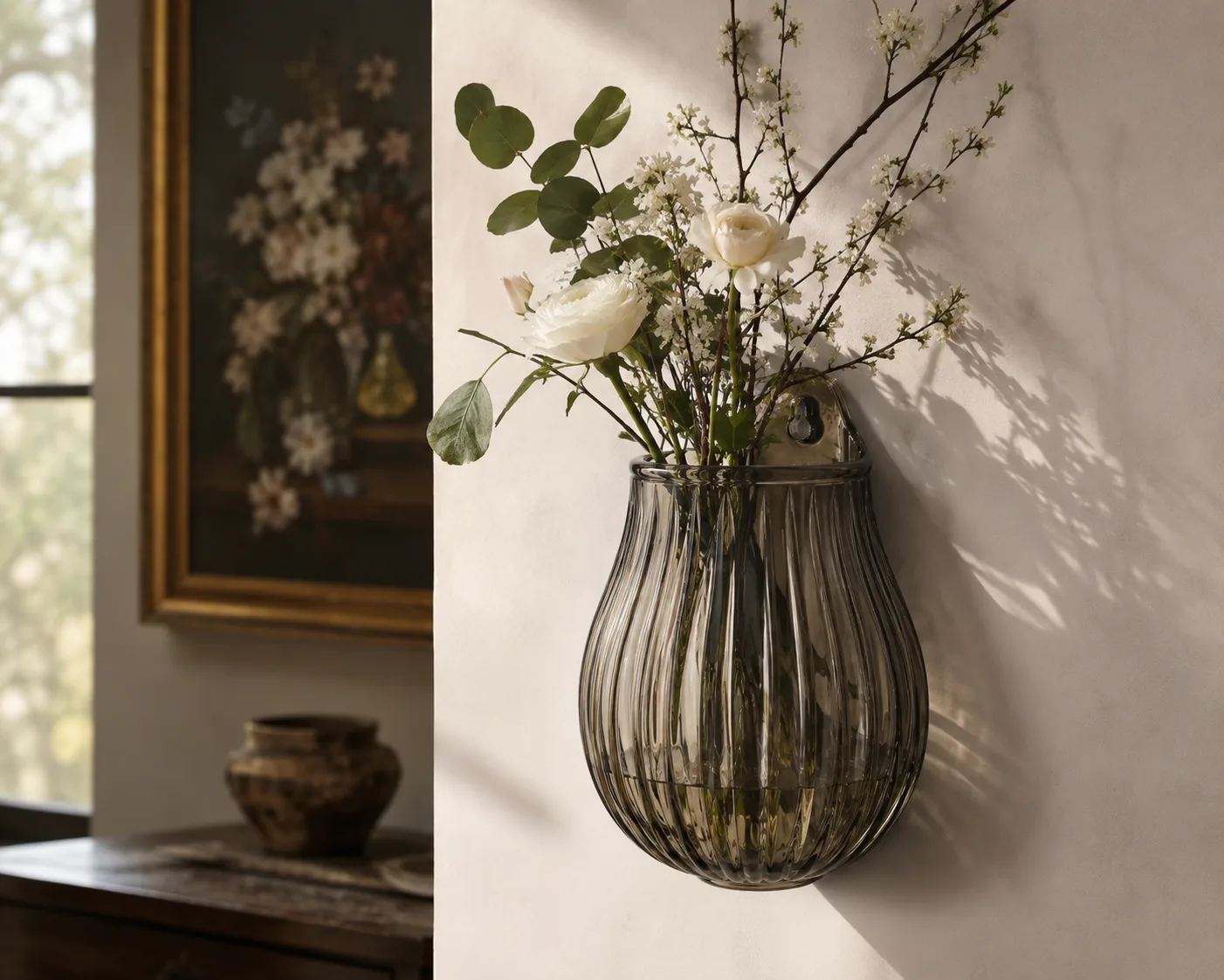 Glas-Wandhängevase in einem dekorativen Blumenarrangement für wandmontierte Pflanzen und kompakte Blumenpräsentation.